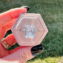Load image into Gallery viewer, Hexagonal pink velvet box with Valentina ring held by a hand outdoors.
