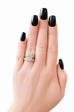 Load image into Gallery viewer, Hand with black nail polish wearing a stack of 3 silver ring on a white background