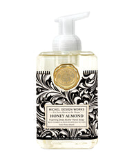 Load image into Gallery viewer, Michel Design Works Honey Almond Foaming Shea Butter Hand Soap in a clear rectangular bottle with a white pump, black and white ornate label, and a gold seal.
