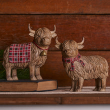 Load image into Gallery viewer, Two highland cows with red and black check bow or cover on a book with wood background
