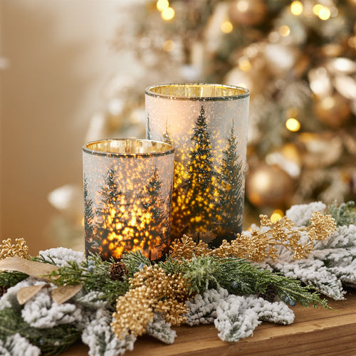 Frosted pine mercury glass candle holders glowing with warm candlelight and decorative pine