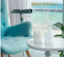 Load image into Gallery viewer, Inis candle and diffuser on a table with a blue chair and window in the background
