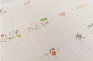 Karen Adams 2026 Calendar artwork display showing multiple hand-glittered designs