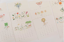 Load image into Gallery viewer, Karen Adams 2026 Desk Calendar monthly cards with foil details and illustrated artwork
