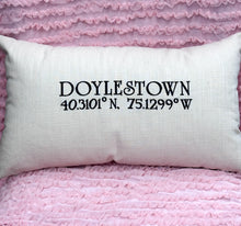 Load image into Gallery viewer, White pillow with 'DOLESTOWN' and coordinates on a pink textured background
