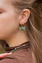 Load image into Gallery viewer, Close-up of a person wearing a dragonfly earring and a necklace with green beads.
