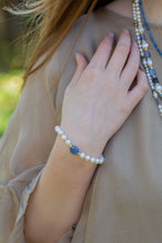 Load image into Gallery viewer, Model wearing handcrafted freshwater pearl and kyanite bracelet with sterling silver lobster clasp
