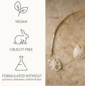 Product packaging with vegan, cruelty-free, and sulfate-free icons on a marble background.